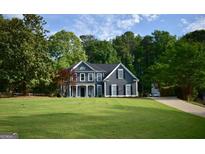 Charming two-story home with a well-manicured lawn and traditional architectural details at 219 Maple Creek Chase, Woodstock, GA 30188