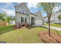 Charming two-story home with a well-manicured lawn and light blue siding, complemented by an attached two-car garage at 107 Cedar Brook Dr, Canton, GA 30115