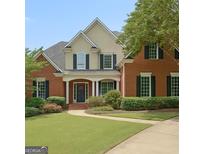 Charming brick home featuring a well-manicured lawn and inviting entrance with black shutters at 102 Passage Pt, Peachtree City, GA 30269