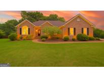 Charming brick home with manicured lawn, mature landscaping, and inviting entryway at 186 Ashley Dr, Mcdonough, GA 30252