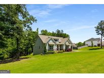 Charming, craftsman home with a lush green lawn and professional landscaping at 30 Hollyhock Ln, Covington, GA 30014