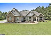 Charming craftsman-style home with stone accents, lush landscaping, and inviting entrance at 45 Coral Ridge Ct, Palmetto, GA 30268