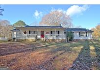 Charming home with a welcoming front porch and a beautiful lawn on a sunny day at 435 Crabapple Rd, Fayetteville, GA 30215