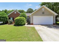 Charming single-story home with well-manicured lawn and attached two car garage at 422 Old Ivy Path, Mcdonough, GA 30253