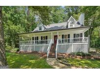 Charming home featuring a spacious wrap-around porch, black shutters, and a well-manicured lawn at 230 Vienna Way, Douglasville, GA 30134