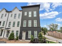 Modern three-story home with a combination of white and gray exterior and large windows at 3587 Candler Ct, Hapeville, GA 30354