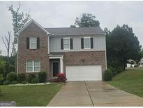 Charming two-story home with brick accents, attached garage, and well-maintained front yard at 7253 Lacey Dr, Douglasville, GA 30134