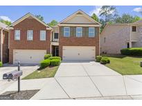 Charming brick townhome featuring a two-car garage and well-maintained landscaping at 2714 Haynescrest Dr, Grayson, GA 30017