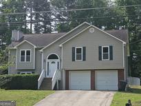 Charming split-level home features a two-car garage, landscaped yard, and welcoming front porch at 54 Crestwood Dr, Dallas, GA 30157