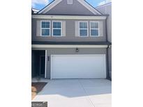 Charming two-story townhome featuring a white garage door, gray siding and white trim at 1017 Merritt Dr Edinberg Dr # 103, Villa Rica, GA 30180