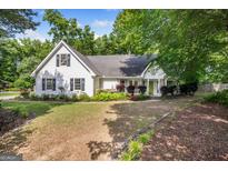 Charming white home with a manicured lawn, complemented by a bright green front door at 19 Indian Bluff Dr, Sharpsburg, GA 30277