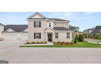 Beautiful two-story townhome featuring a brick facade, a two-car garage, and a professionally landscaped yard at 580 Silver Moon Dr, Loganville, GA 30052