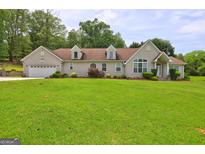 Charming single-story home featuring an attached garage, dormer windows, and a well-manicured lawn at 260 Sams Dr, Fayetteville, GA 30214