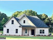 Charming single-story home with white brick, dark roof, covered porch, and professionally landscaped yard at 1701 Lake Dow Rd Rd, Mcdonough, GA 30252