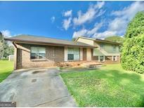 Charming single Gathering home with a brick facade and a well maintained lawn at 102 Crystal River Dr, Riverdale, GA 30274