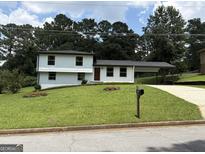 Charming two-story home with a well-manicured lawn and convenient carport at 7340 Chalk Way, Riverdale, GA 30296