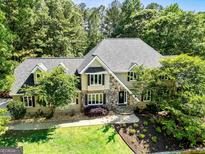 Beautiful two-story home featuring stone accents, a manicured lawn, and a classic front door entrance at 324 Chimney Sweep Cir, Peachtree City, GA 30269