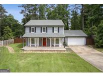 Charming gray two-story home featuring a welcoming front porch, red door, and lush green lawn at 120 Bowfin Bay, Peachtree City, GA 30269