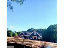 Newly constructed home with dark blue siding and white trim, situated on a spacious lot at 1273 Jersey Social Circle Rd, Covington, GA 30014
