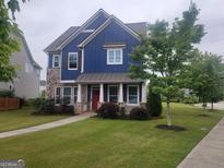Charming two-story home with blue siding, stone accents, a manicured lawn and a welcoming red front door at 1946 Jeffery Nw Rd, Atlanta, GA 30318