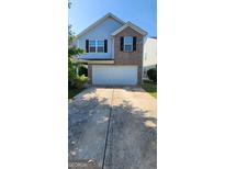 Two-story home with a brick facade, blue siding, and a two-car garage at 1562 Onalee Dr, Hampton, GA 30228