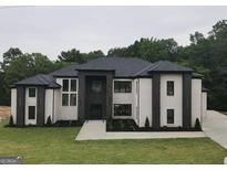 Stunning two-story home featuring a modern design with black and white brick and a well-manicured lawn at 972 Auburn Rd, Dacula, GA 30019