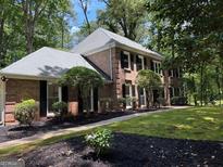 Well-maintained brick home with mature trees and lush landscaping offering great curb appeal at 335 Cedar Ln, Fayetteville, GA 30214