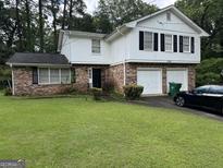 Charming two-story home with brick and siding, featuring a well-manicured lawn and two-car garage at 1328 Kimlie Ln, Decatur, GA 30035