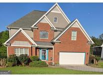 Charming two-story brick home with a manicured front yard and a two-car garage, creating an inviting curb appeal at 3932 Misty Lake, Ellenwood, GA 30294