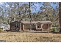 Charming single-story home featuring a brick facade, covered porch, and well-manicured yard at 2545 Rockbridge Nw Rd, Conyers, GA 30012