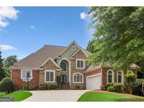 Beautiful two-story home showcasing a brick and stone facade, well-manicured landscaping, and a spacious driveway on a sunny day at 1029 Ector Nw Dr, Kennesaw, GA 30152