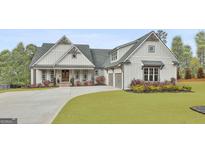 Charming home with a large front yard, a welcoming porch, and a three-car garage at 415 Discovery Lake Dr, Fayetteville, GA 30215