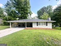 Charming single-story home with a spacious carport, mature trees and a well-maintained lawn at 3375 Brenda Ln, Lithia Springs, GA 30122