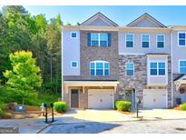 Charming townhome with brick facade, attached garages, well-maintained landscaping and inviting curb appeal at 1005 Belfry Ter, Fairburn, GA 30213