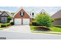Charming brick home with a two-car garage and well-manicured lawn and landscaping at 335 Grand Teton Cir, Fayetteville, GA 30215