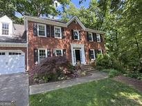 Charming two-story brick home with black shutters and attached garage in wooded setting at 3146 Weymouth Dr, Marietta, GA 30062