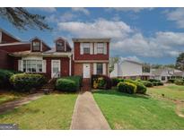 Charming townhome featuring a lush green lawn and beautiful landscaping at 5461 Park S Pl, Atlanta, GA 30349