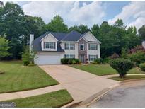 Charming two-story home with a two-car garage, stone accents, manicured lawn, and lovely curb appeal at 75 Trelawney Keep, Covington, GA 30016