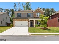 Charming two-story home featuring a brick facade, a two-car garage, and a well-manicured front lawn at 510 Cunninghame Ct, Peachtree City, GA 30269