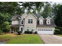 Charming two-story home with a two car garage, manicured lawn, and traditional architectural details at 110 Shelby Oaks Trl, Covington, GA 30016