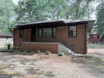 Charming brick home with a quaint front porch and freshly landscaped yard at 1684 Lake Harbin Rd, Morrow, GA 30260