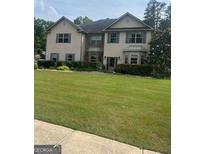 Traditional two-story home featuring a well-manicured lawn and beautiful landscaping at 465 Harris Dr, Conyers, GA 30012
