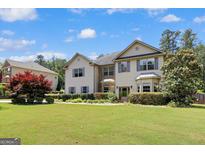 Charming home featuring a well-manicured lawn, complemented by lush greenery and neutral siding at 465 Harris Dr, Conyers, GA 30012