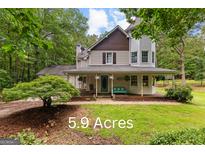 Charming two-story home with a large porch and beautiful landscaping on 5.9 acres at 135 Birdsong Ln, Fayetteville, GA 30215