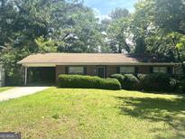 Charming single-story brick home featuring a covered carport and mature landscaping at 2820 Lloyd Rd, Decatur, GA 30034