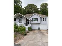 Charming two-story home with a two car garage and a welcoming front porch at 227 Cedars Glen Cir, Villa Rica, GA 30180
