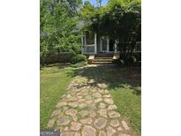 Charming home featuring a stone walkway leading to a covered porch with classic white railings and stone accents at 5780 Pumkintown Rd, Douglasville, GA 30135