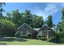 Charming brick home with mature trees, well-maintained lawn, and inviting curb appeal at 9160 Woodhaven Way, Mcdonough, GA 30253