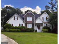Charming two-story home with stone accents, a well-manicured lawn, and mature landscaping at 74 Flanders Ct, Douglasville, GA 30134