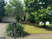 Charming two-story home featuring lush landscaping and a welcoming front porch, complemented by a well-maintained lawn at 34 Hunters Xing, Dallas, GA 30157